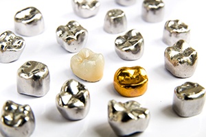 Several dental crowns made of different materials on a white background