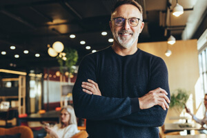 Man with black glasses smiling in office