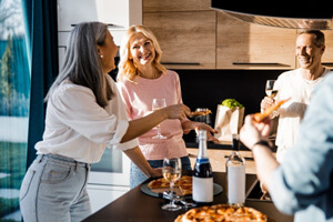 Group of friends smiling and talking in kitchen