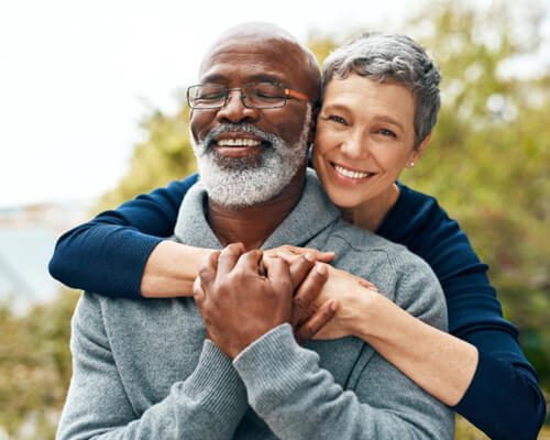 Senior couple standing outside and smiling