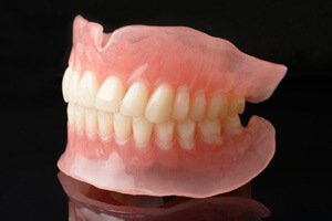 Full denture sitting on a black reflective surface