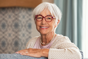 Senior woman in sweater sitting on couch